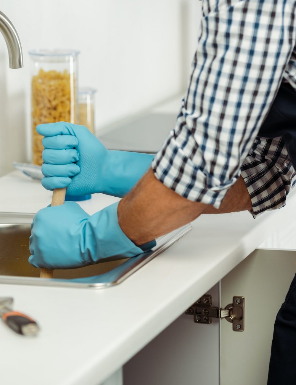 cropped-view-of-plumber-in-tool-belt-and-rubber-gloves-cleaning-blockage-of-kitchen-sink.jpg